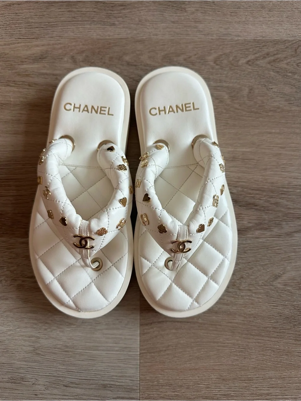 CHANEL 23S White Quilted Logo Flip Flops with Gold Charms